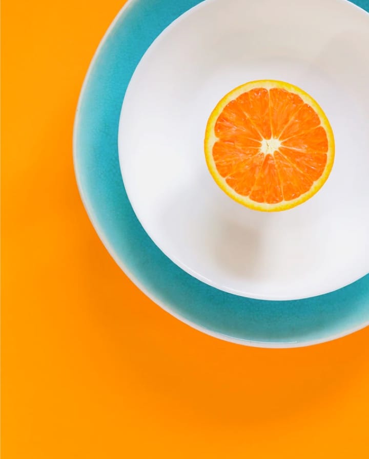 Half cut orange placed on the plate 