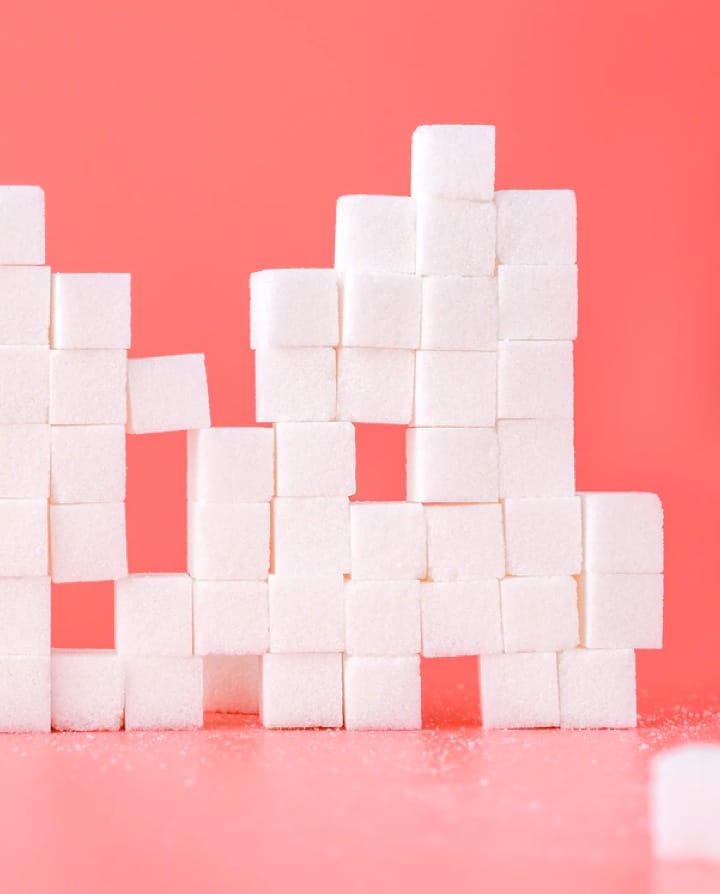 White sugar cubes next to the pink background.