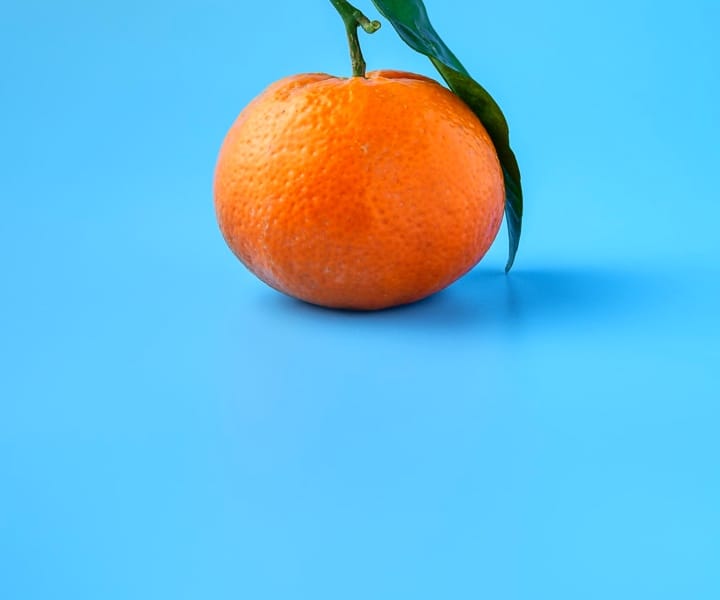 Orange with leaf is on blue background