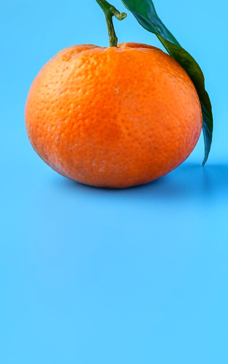 Orange with leaf is on blue background